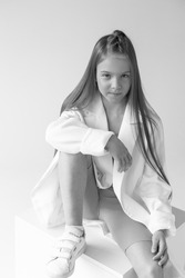 Stylish smiling fashionable young girl monochrome portrait in elegant suit and sport wear on white background.