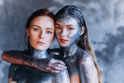 Young beautiful lgbt girls in fantastic creative makeup with rhinestone, dark background. Art beautiful women with cosmic make-up on face and body blue and silver skin color 