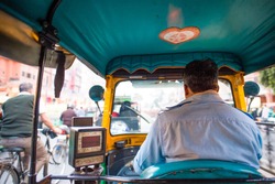 A rickshaw (also known as Tuc Tuc) driver is driving in the streets of Agra in India. Agra is a city on the banks of the river Yamuna in the northern state of Uttar Pradesh