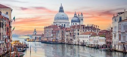Stunning view of the Venice skyline with the Grand Canal and Basilica Santa Maria Della Salute in the distance during a dramatic sunrise. Picture taken from Ponte Dell’ Accademia.