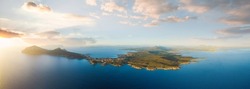View from above, aerial shot, stunning panoramic view of Golfo Aranci during a beautiful sunrise. Golfo Aranci is a village that extends along a strip of land into turquoise sea. Sardinia, Italy.