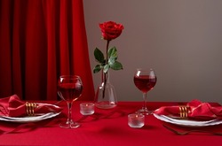 Romantic table setting with white dinnerware and red napkins, wine and candles. Valentines day or romantic dinner concept. Romantic Dinner.