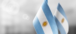 Small national flags of the Argentina on a light blurry background