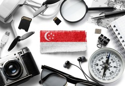 Flag of Singapore and travel accessories on a white background.