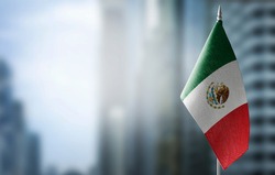 A small flag of Mexico on the background of a blurred background