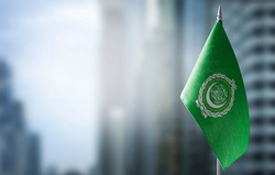 A small flag of Arab League on the background of a blurred background