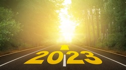 The word 2023 written on forest road. Concept for new year 2023. The route to the new year indicated by the arrow. Anniversary planning for hope and future concept