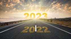 2023 anniversary. Transition from 2022 to the new year. Golden sunrise on asphalt empty road. New year concept with the number 2023 on the horizon.