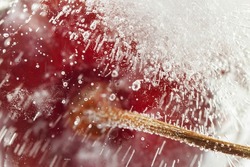 Cherry fresh berry frozen inside ice cube with stick,  bubbles and water marks inside for cool macro abstract wallpaper pattern