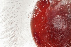 Cherry fresh berry frozen inside ice cube with bubbles and water marks inside for cool macro abstract wallpaper pattern