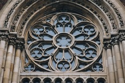 Round openwork window with stained glass on the facade of the building. Baroque and Gothic architecture. Church of St. Olga and Elizabeth. Lviv, Ukraine.