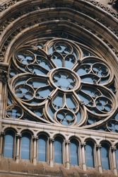 Old openwork round window with stained glass on facade of the building. Baroque and Gothic architecture. Church of St. Olga and Elizabeth. Lviv, Ukraine.