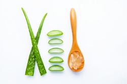 Aloe vera fresh leaves with slices and aloe vera gel on wooden spoon. isolated over white.