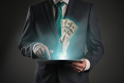 Get money online. Money cashback from internet store. Online payment or deal. Businessman with a tablet computer in hands and hand with cash.
