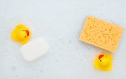 High Angle View of yellow rubber duck in bath swimming in foam water. Yellow rubber ducklings in soapy foam, fun for kids.