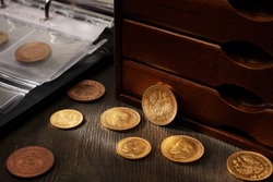 Numismatics. Old collectible coins made of silver, gold and copper on a wooden table. 