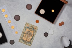 Numismatics. Old collectible coins made of silver, gold and copper on a wooden table. Top view. Copy space of your text.