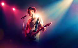 Rock singer with a guitar in stage lights