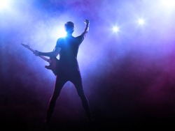 Silhouette of guitar player in stage lights