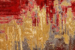 Texture of oriental red-gold carpet tapestry with abstract pattern, closeup.