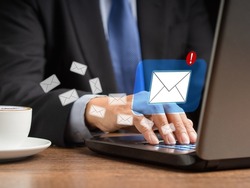 A businessman receives a new message with email icons on a virtual screen. Email notification on the laptop. Email marketing concept. Close-up photo
