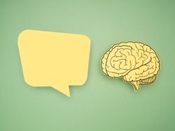 Yellow speech bubble and brain shape made from paper on a green background. Awareness of Alzheimer's, Parkinson's disease, dementia, stroke, seizure, or mental health. Neurology and Psychology care