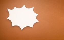 A blank white comic speech bubble on a brown background. Space for text. Top view