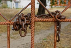 large old rusty iron chain on brown reinforcement bars