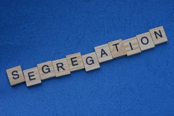 word segregation  made from  wooden letters lies on a blue table