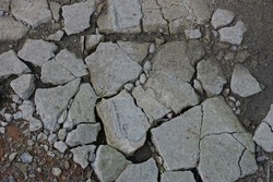 texture of white pieces of stones with cracks on the gray ground on the street