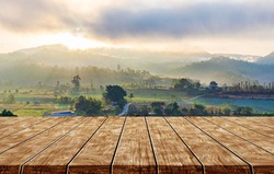 wooden table and mountain farm landscape in sunlight