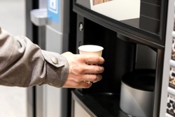 Man hand with coffee, vending coffee machine