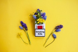 
cigarette pack with flowers inside on a yellow background. no smoking concept, smoking kills, world no tobacco day