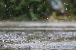 Rain is falling heavily due to sudden thunderstorms and summer storms, causing the downpours to not be able to drain quickly into the sewers, causing rain water to pool on the road surface.