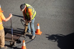 Construction worker jackhammering a city street, with space for text on the right