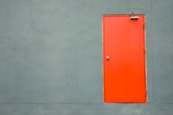 Red iron door on a gray wall