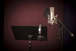 Voice recording studio set up, with microphone, music stand and headphones, horizontal