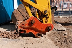 A quick-hitch fitted to an excavator for rapidly mounting or dismounting attachments like a bucket or a hydraulic breaker. Also known as a quick coupler