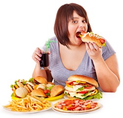 Overweight woman eating fast food.