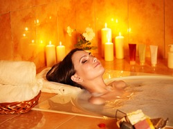 Young woman take bubble  bath with candle.