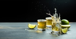 Mexican tequila with lime and salt on stone background. concept luxury drink. Alcoholic drink. Freeze motion, drops in liquid splash Mexican national drink. space for text.