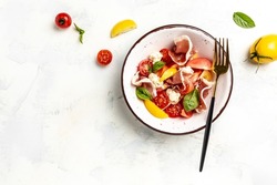 Salad with Prosciutto, ham jamon, tomatoes, cheese. Cold snacks. Food recipe background. Close up top view.