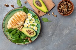 ingredients for a ketogenic diet avocado, grilled chicken fillet, quail egg, spinach, walnut. Healthy fats, clean eating for weight loss, Food recipe background. Close up, top view,