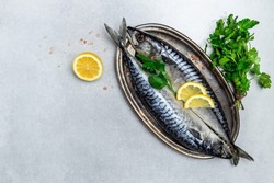 Raw Mackerel fish with salt, lemon and spices on light background. Fresh seafood. Culinary, cooking fish concept. banner, menu, recipe place for text, top view.