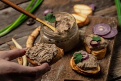 Woman hands spread bread with beans paste, Mexican cuisine pate of beans in glass jar. healthy vegetarian food, top view.