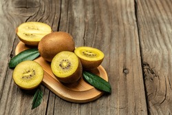 Closeup ripe golden kiwi fruit on wooden background. Healthy fruits concept. place for text, top view.