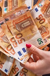 woomen's hand 50 fifty euros bills banknotes on money background