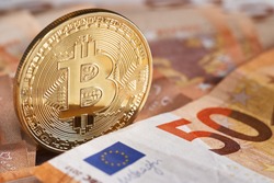 Golden bitcoin on fifty euro banknotes background. Bitcoin crypto currency, Blockchain technology, digital money, Mining concept, bitcoin on 50 euro bill. Macro