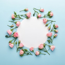 Flowers composition. Wreath made of pink rose flowers on blue background. Flat lay, top view, copy space.