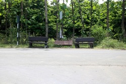 Rcc bench near road side for resting of long travel passenger with background of green trees